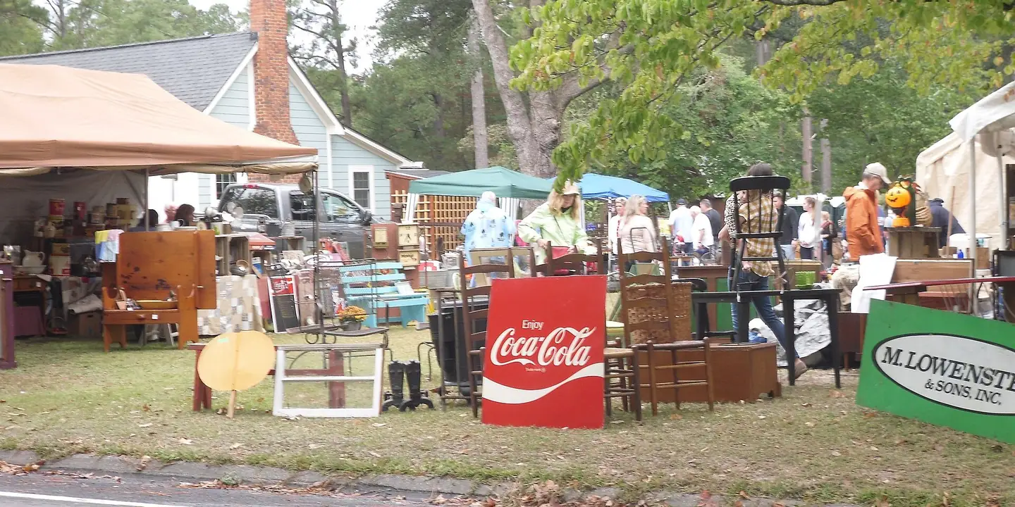 Antique dealers tables and shoppers at an outdoor antiques fair