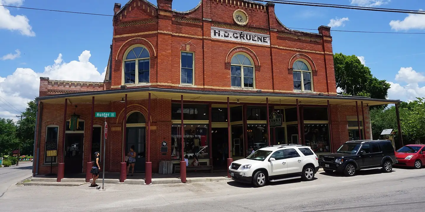Red brick 19th-century commercial building with a long porch