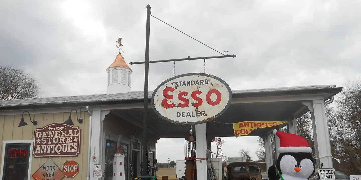 Old Esso gas station sign above a general store and antiques shop
